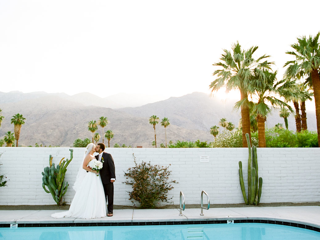 bride and groom kiss near pool at l'horizon palm springs wedding at sunset