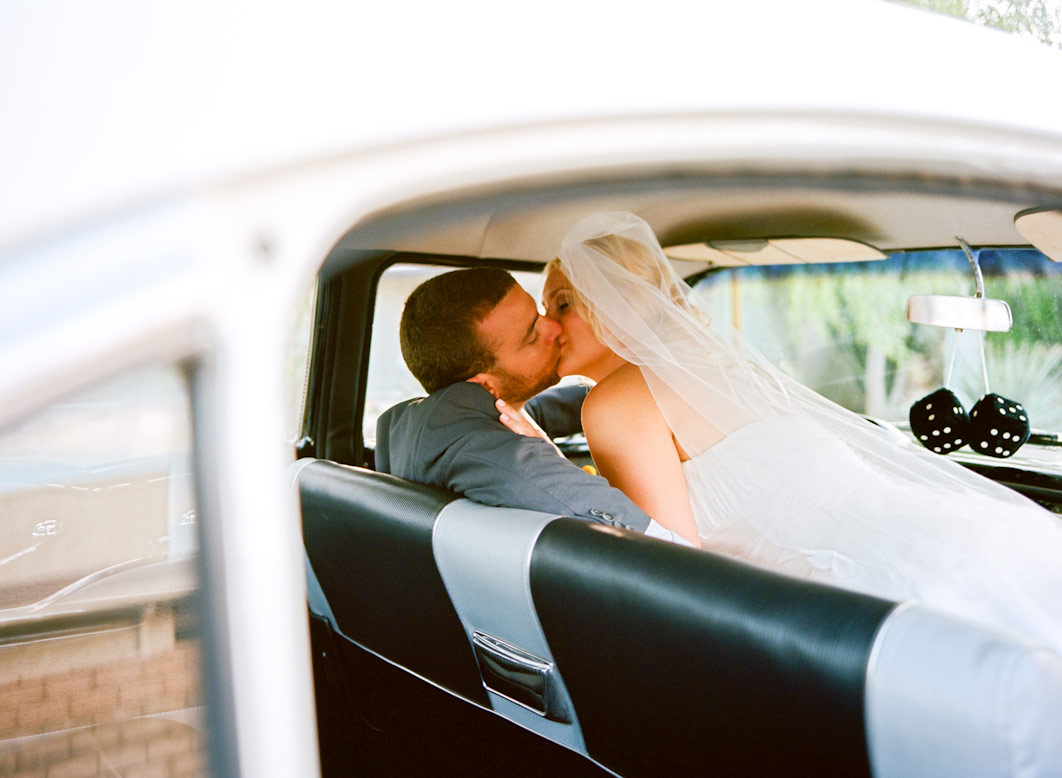 bride and groom kiss in front seat of 1957 chevy bel-air during l'horizon palm springs wedding