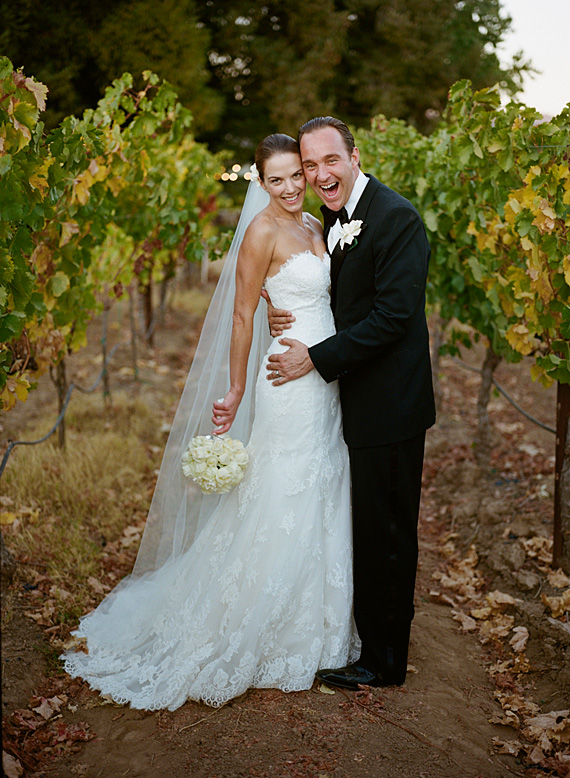 bride and groom laughing in vineyard