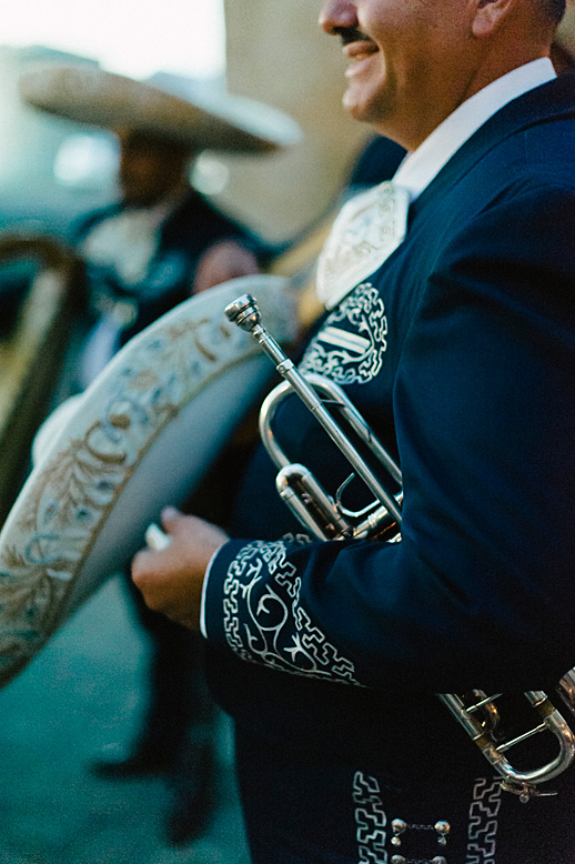 mariachi band member holds trumpet and sombrero