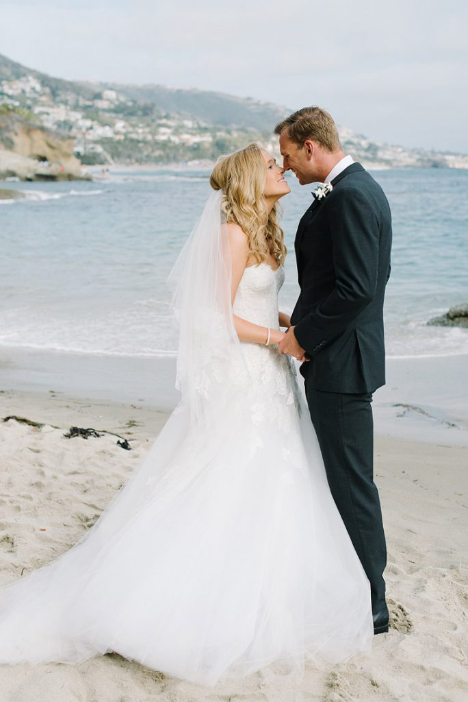 bride and groom embrace on beach montage laguna wedding