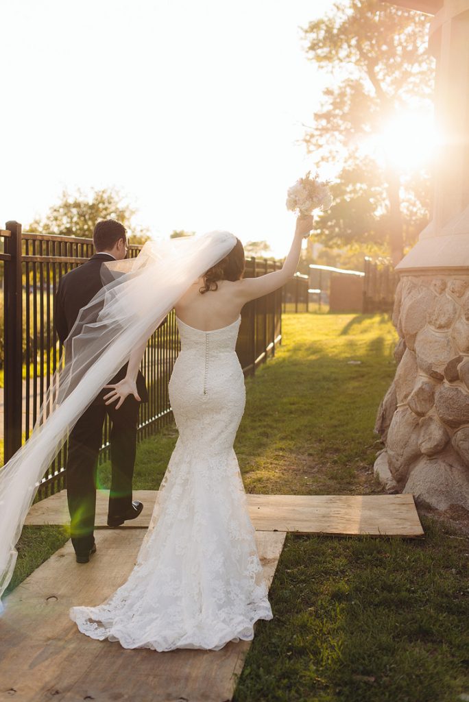 bride raises hand walking with groom into sunset puerto rican arts center wedding