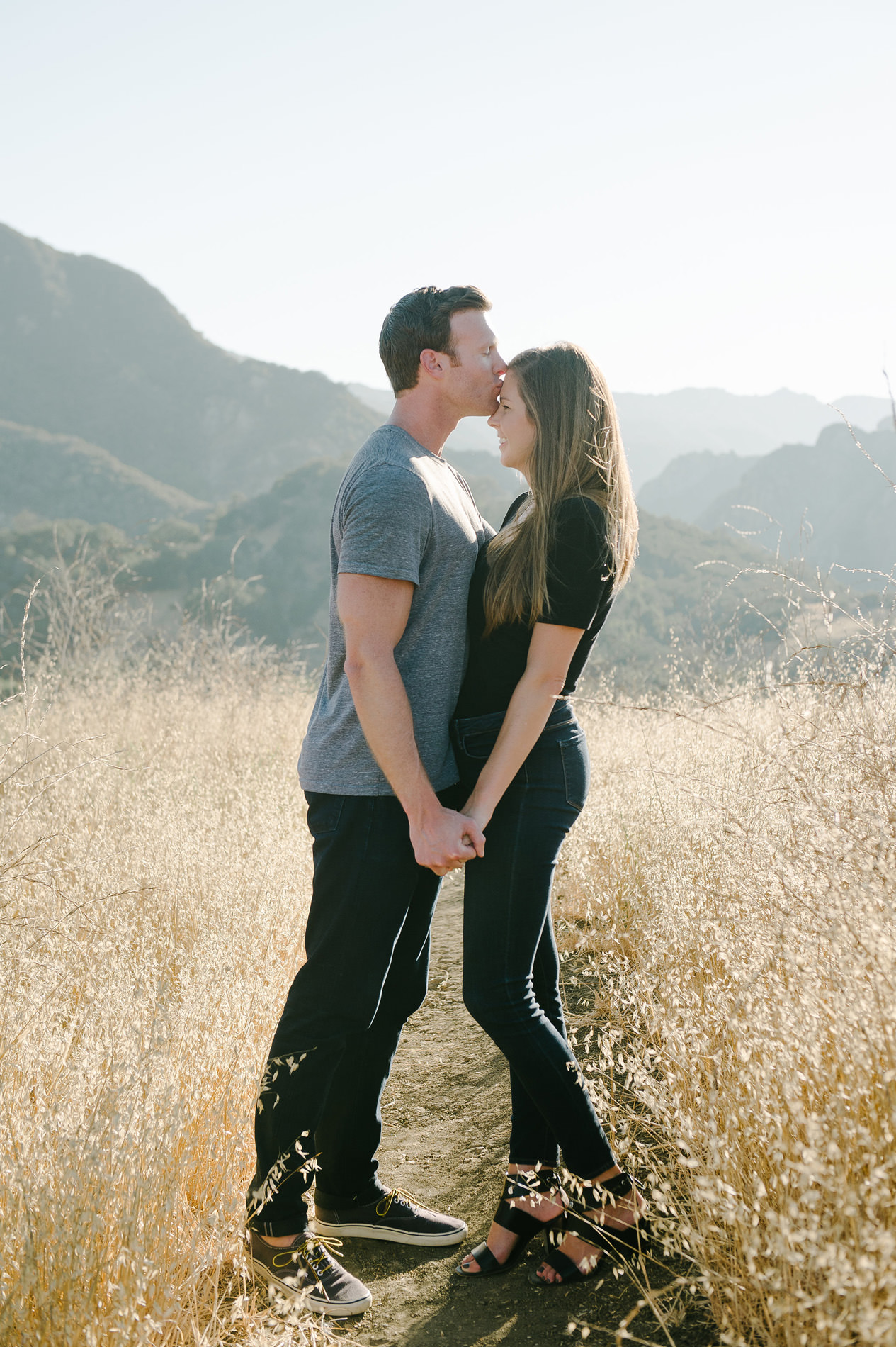 man kissing fiancees head engagement photo shoot malibu creek state park