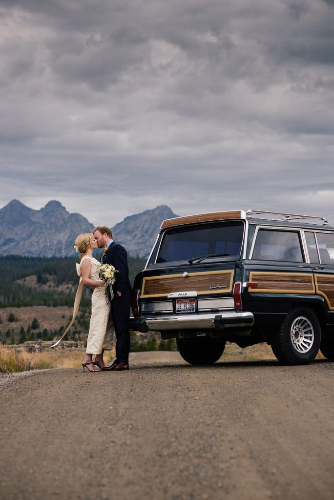 bride groom kiss vintage jeep wagoneer idaho rocky mountain ranch