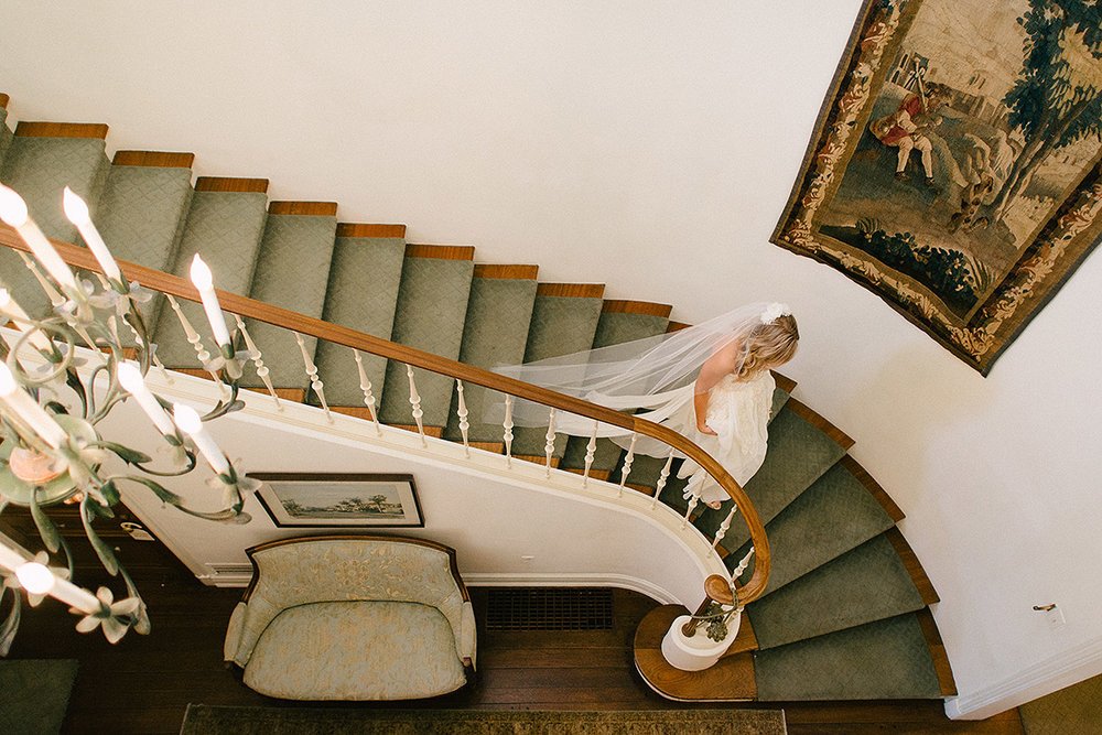 bride walking down spiral staircase darlington house wedding
