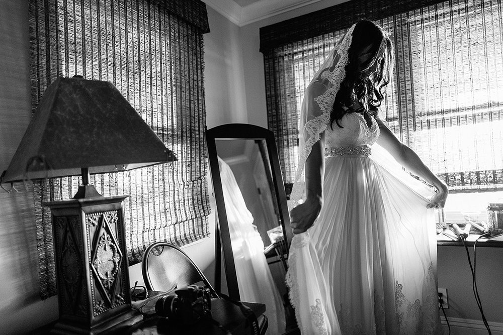bride adjusts wedding dress and veil before her wedding in hawaii