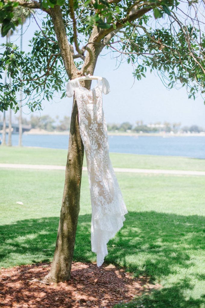 bride's lace gown hangs on tree at dana mission bay