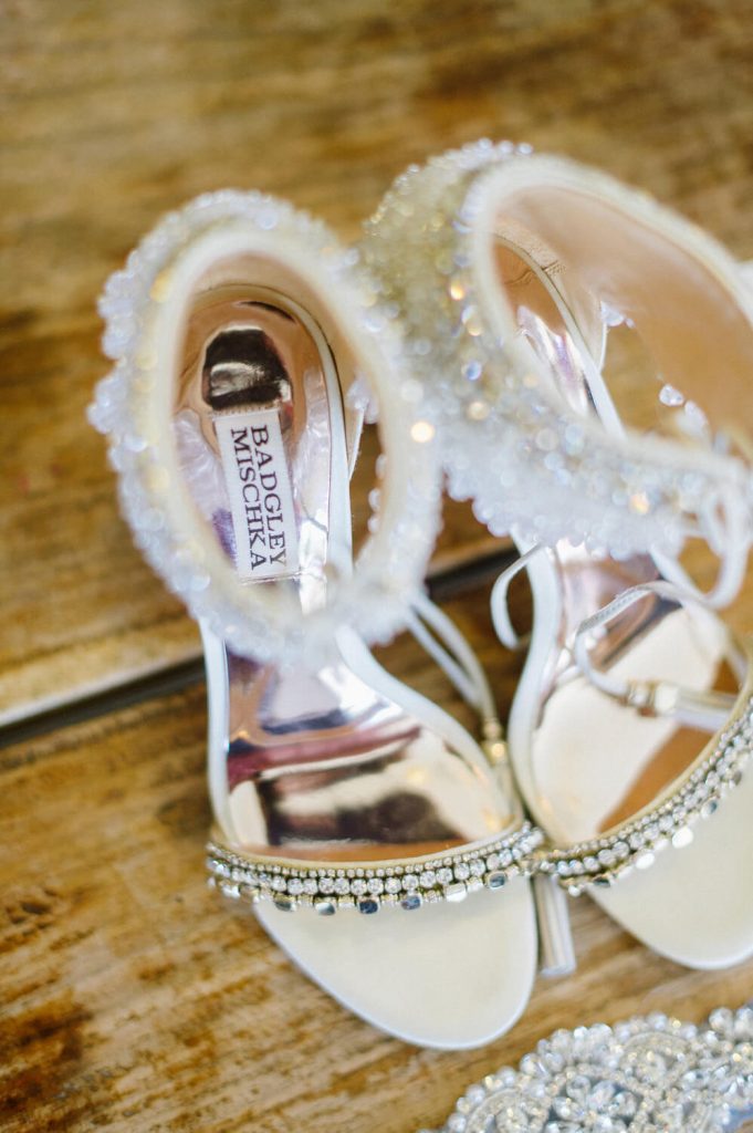bride's badgley mischka shoes on wooden table