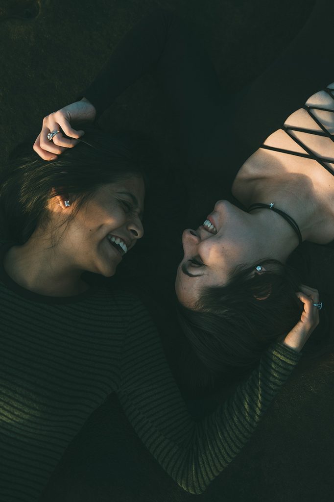 lesbian couple lay down la jolla engagement photo