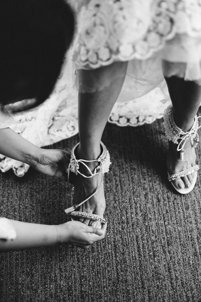 bride puts on badgley mischka shoes before wedding