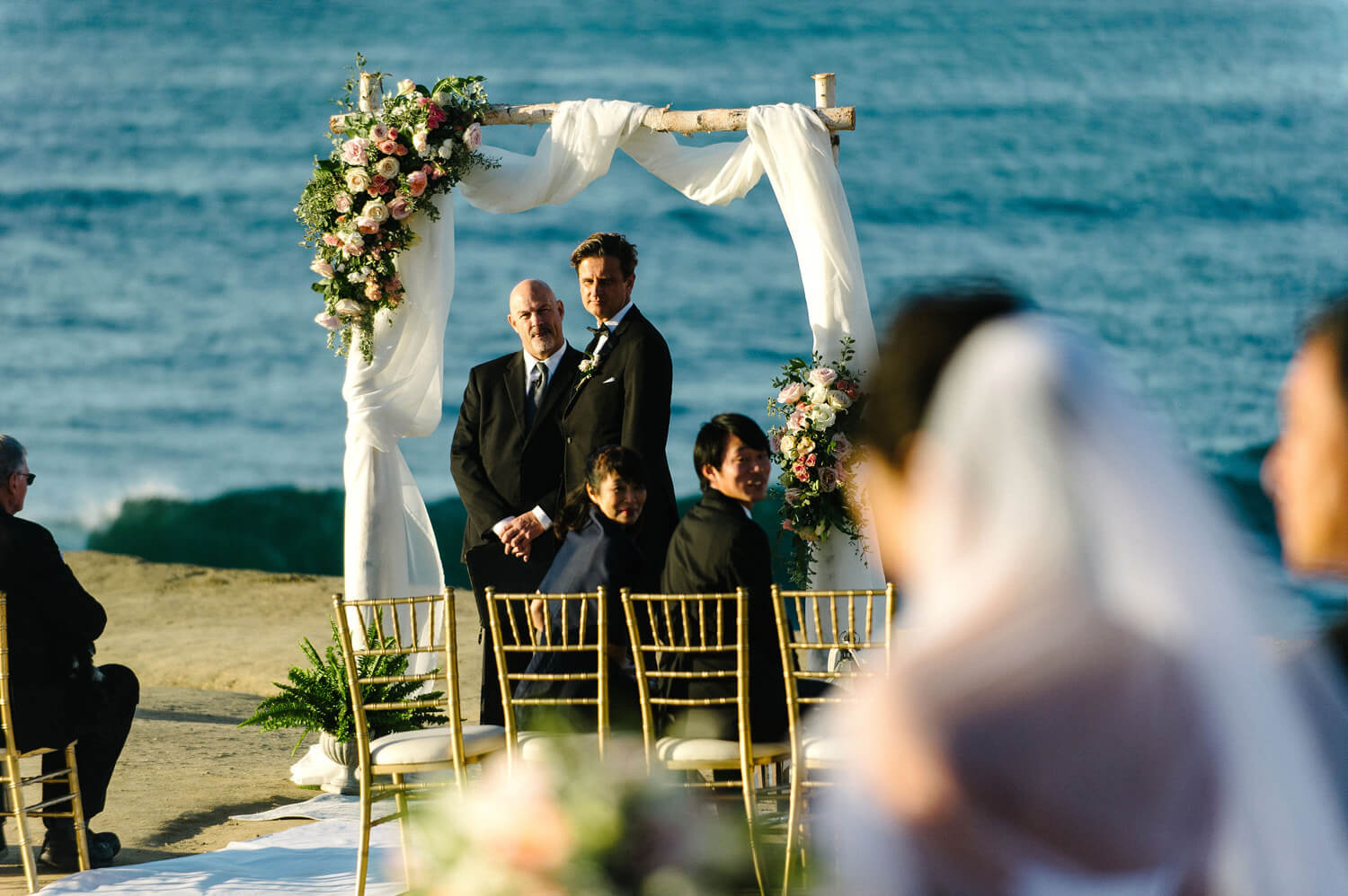 groom watches bride walk aisle sunset cliffs intimate ceremony