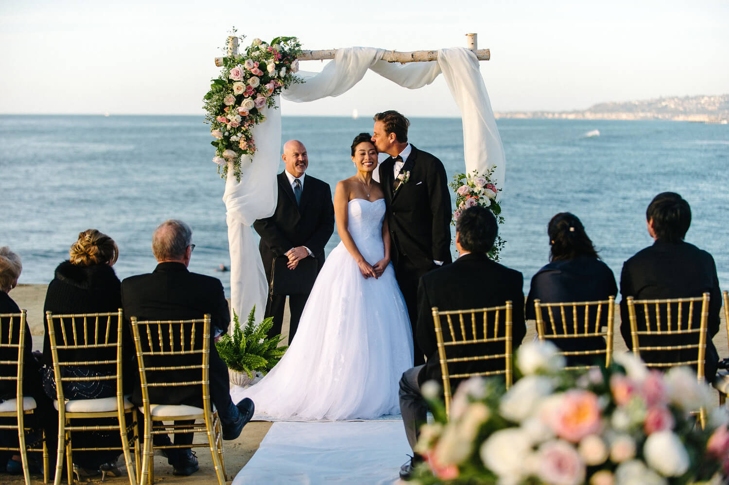 groom sneaks kiss bride sunset cliffs intimate ceremony
