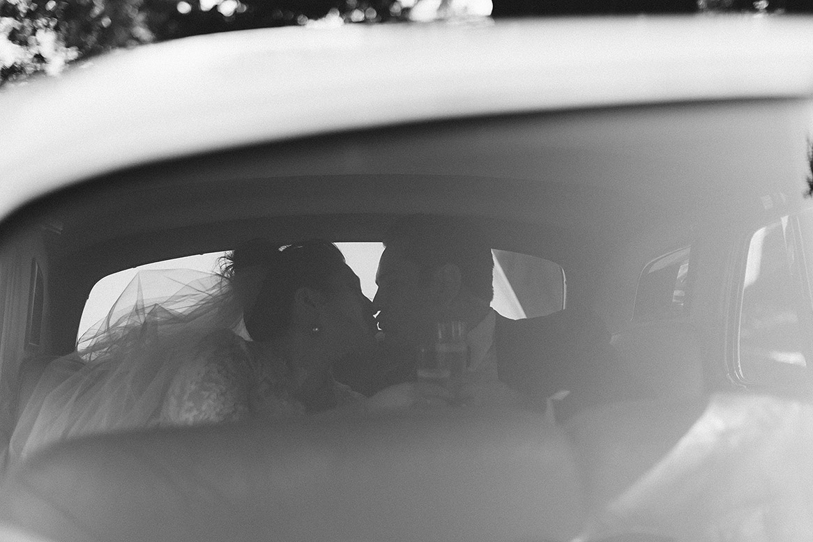 bride and groom kiss in back seat of limousine after portola valley wedding