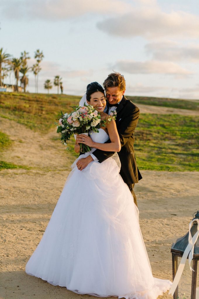bride groom embrace sunset cliffs intimate wedding