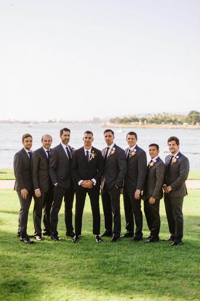 groom and groomsmen pose on lawn at dana mission bay wedding