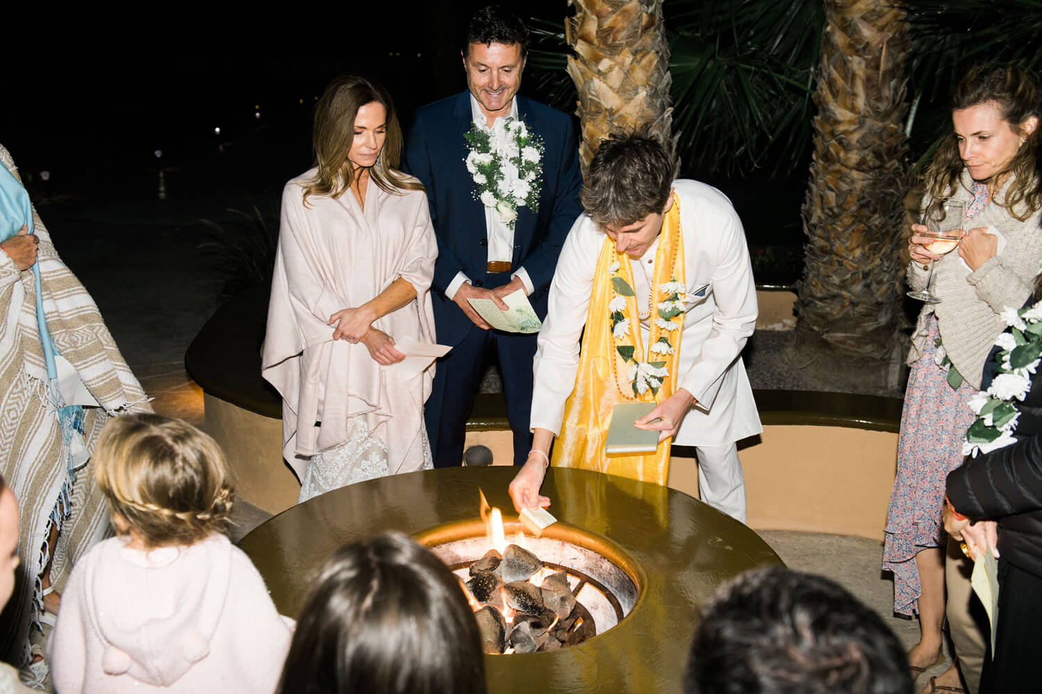 officiant drops paper with intention into fire pit loreto mexico wedding