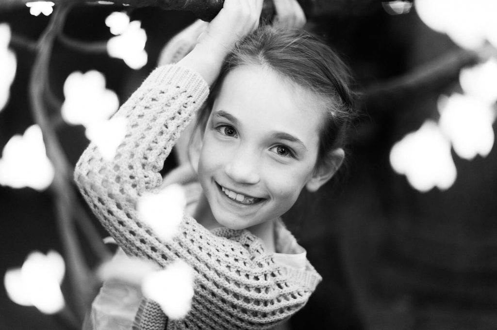young flower girl tree lights portrait