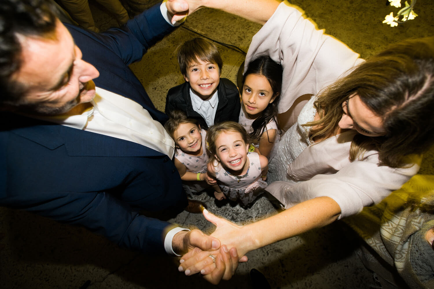 bride groom dance hold hands around four children wedding reception