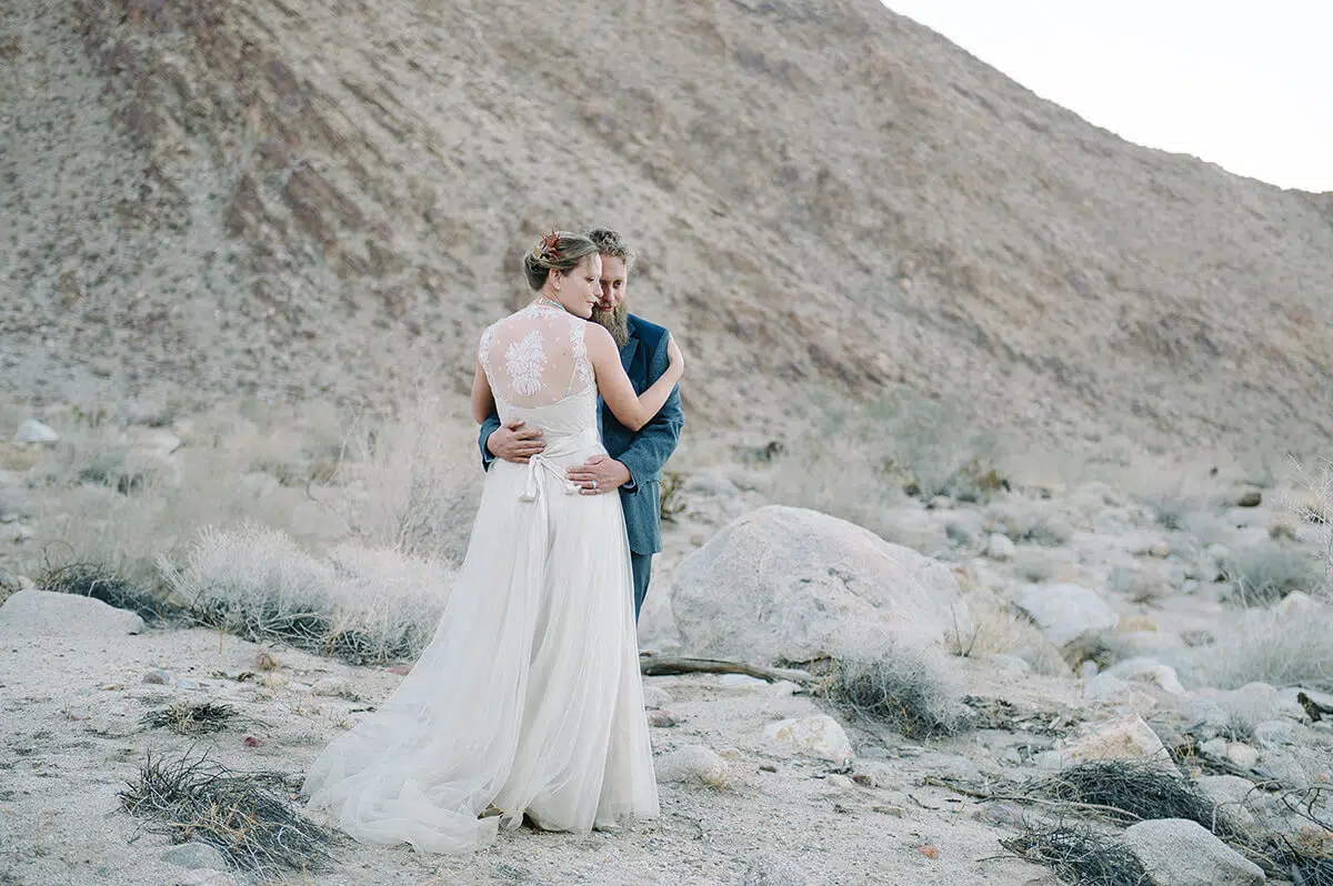 bride and groom embrace amongst desert landscape in borrego springs