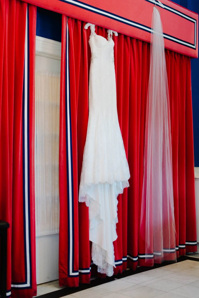wedding gown hangs on red drapes congress hall bridal suite