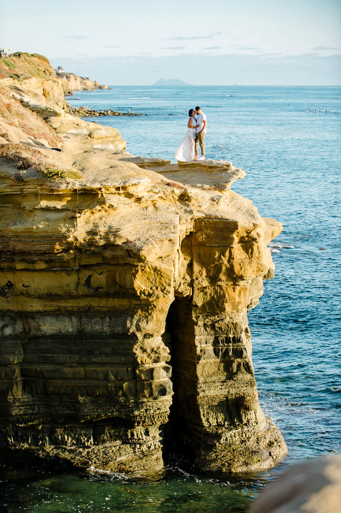couple kiss sunset cliffs above ocean