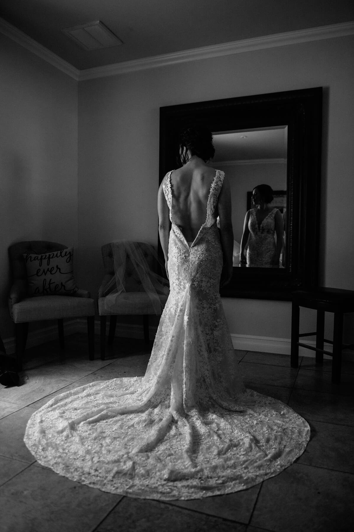bride in lace gown waits in bridal suite before leoness cellars wedding