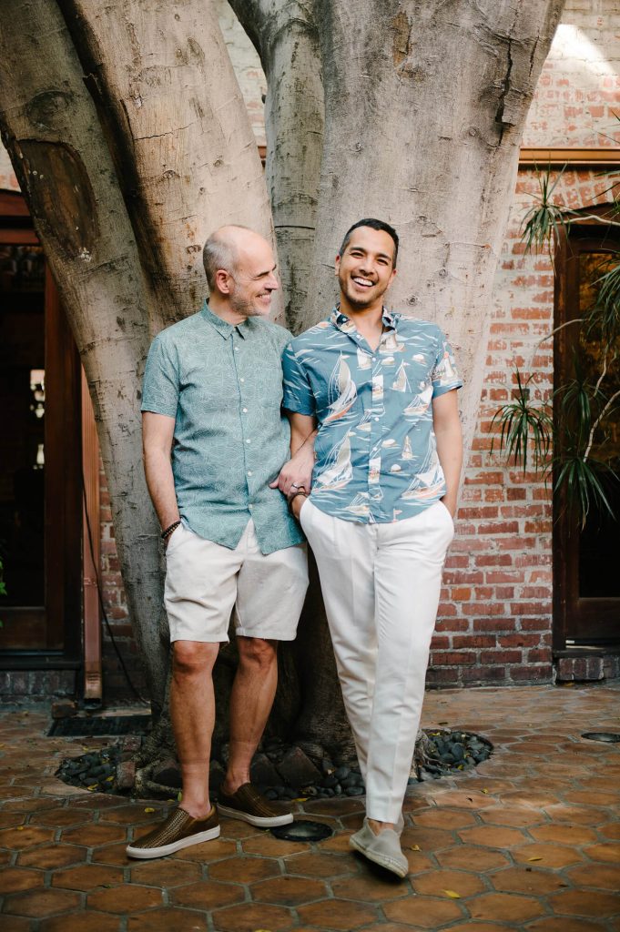 two grooms embrace courtyard carondelet house engagement