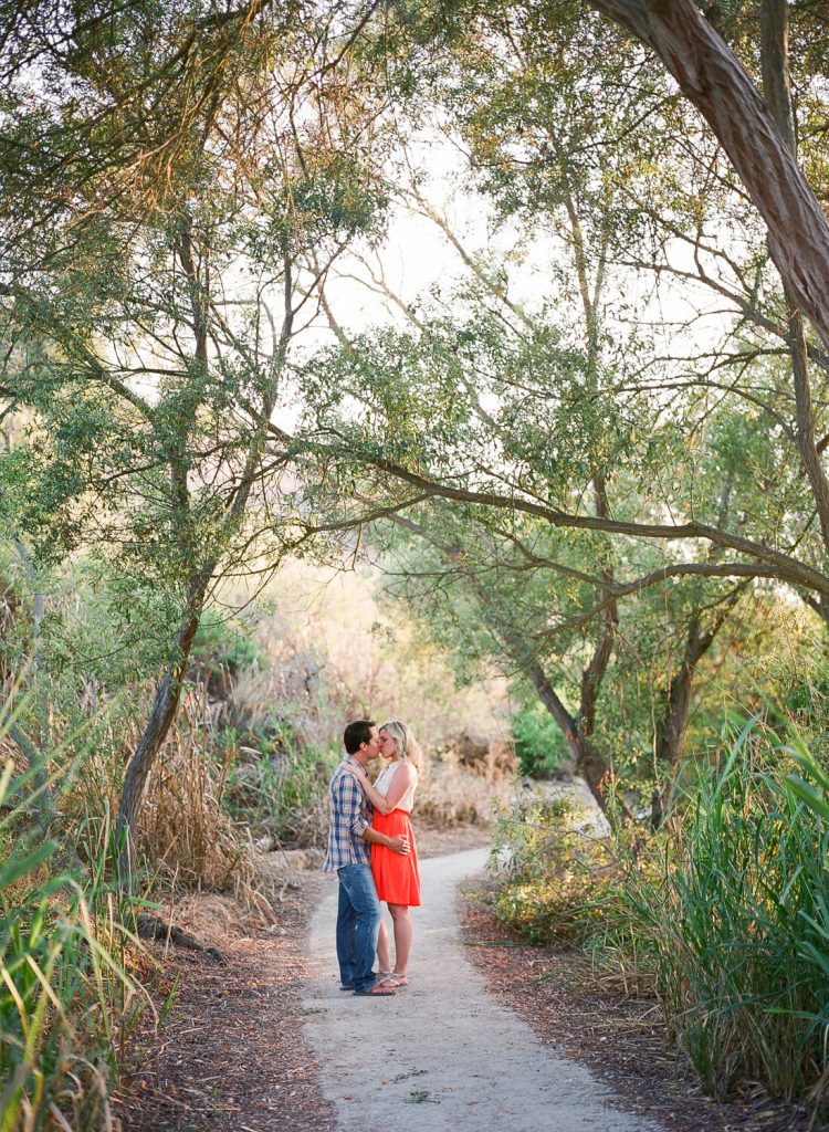 couple kissing under trees crystal cove