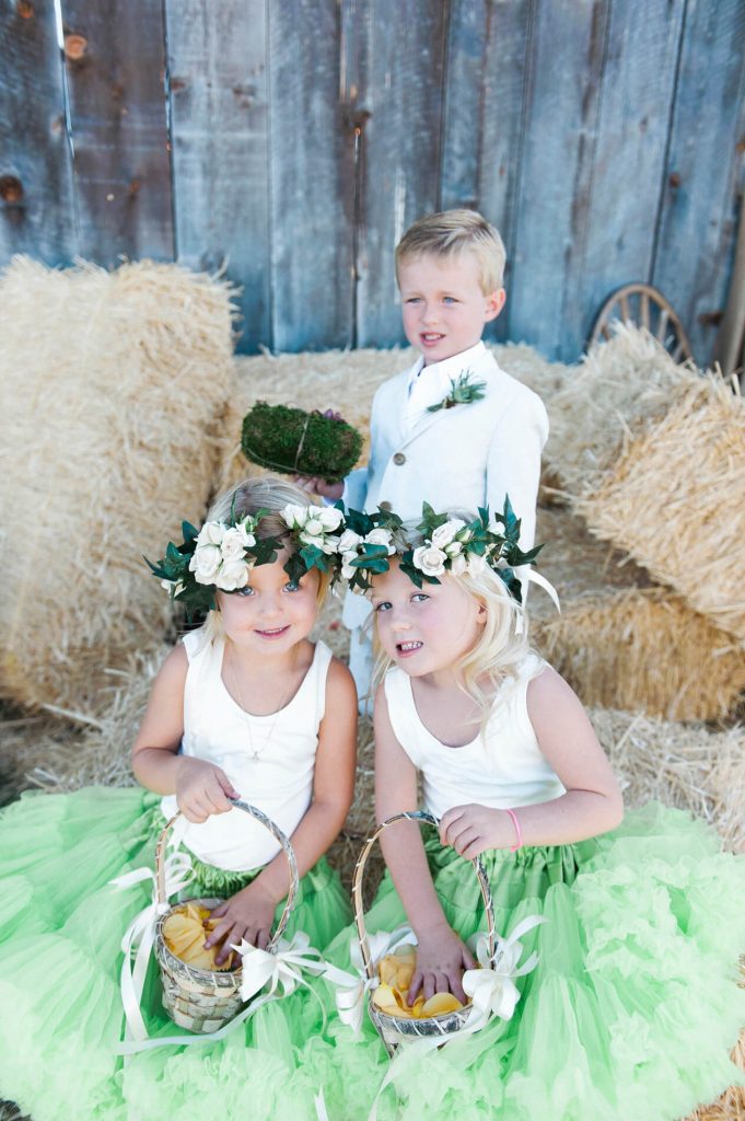flower girls wearing green tutus and flower headbands and ring bearer in tan suit rustic barn wedding