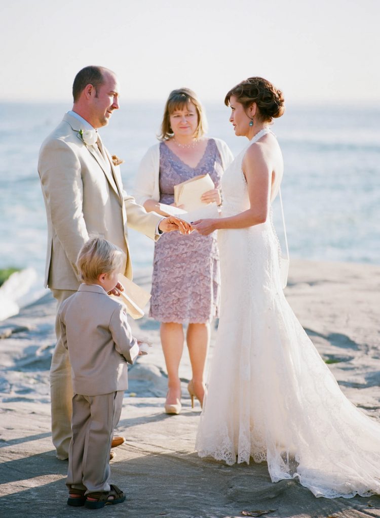 bride and groom recite vows on rocks during windansea beach wedding 