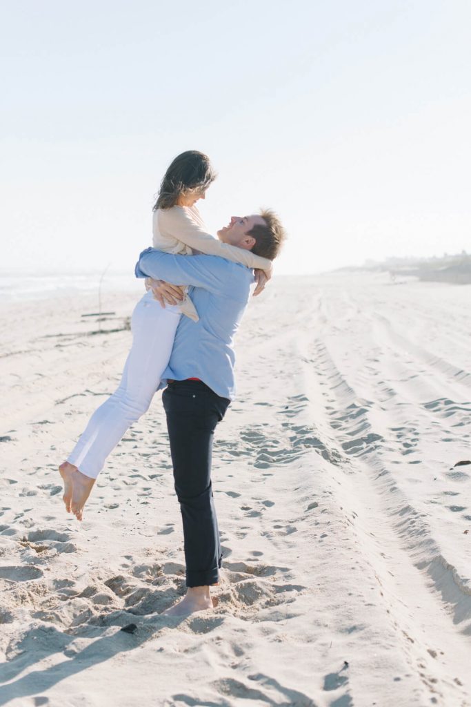 man lifting fiancee off feet beach hamptons engagement photo