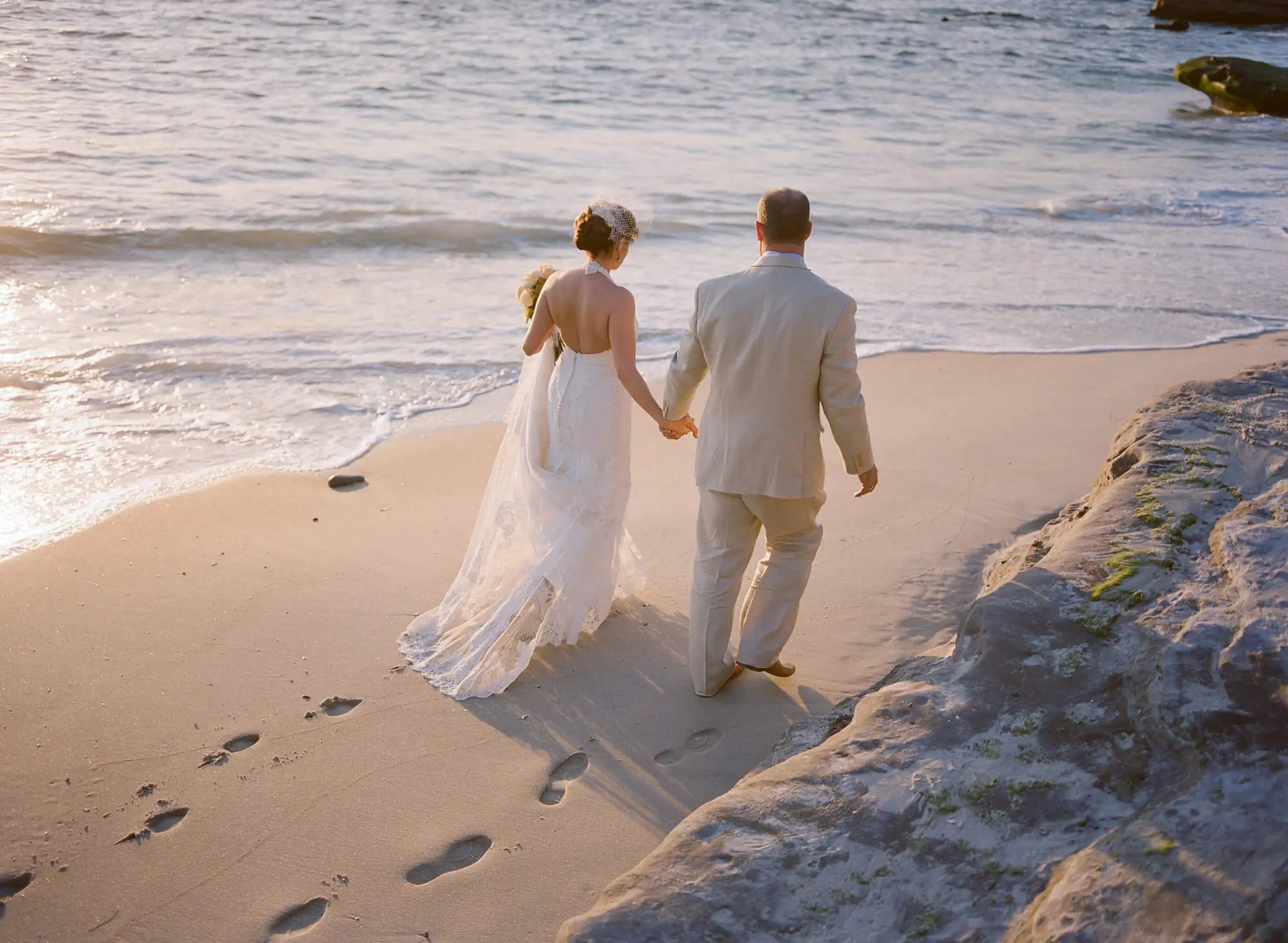 bride and groom walking holding hands windansea beach wedding