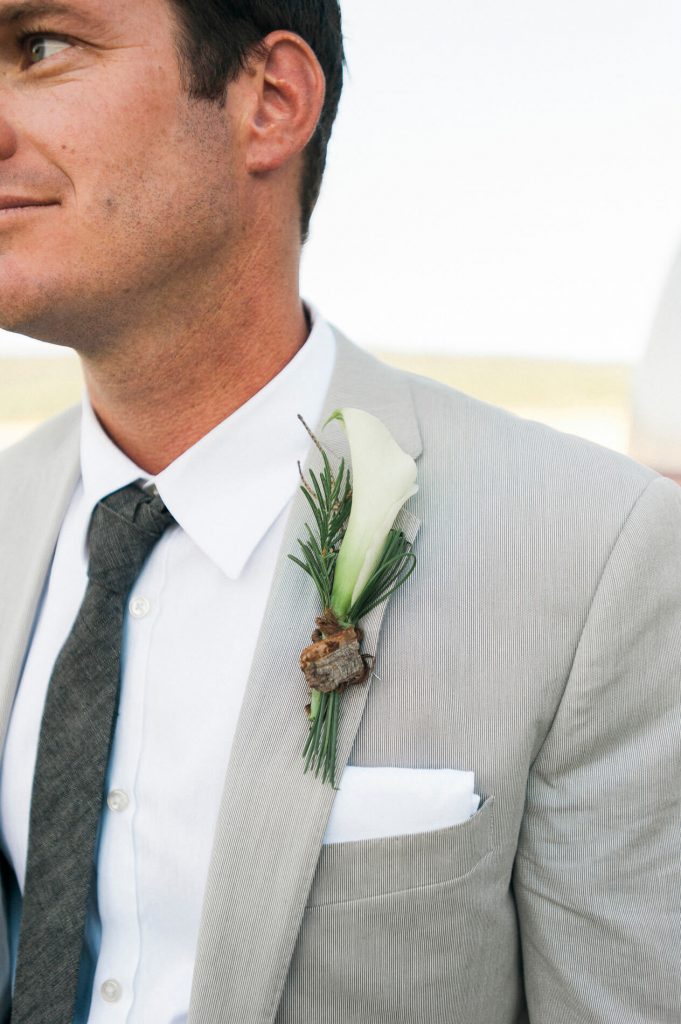 groom in tan suit with calla lily boutonniere