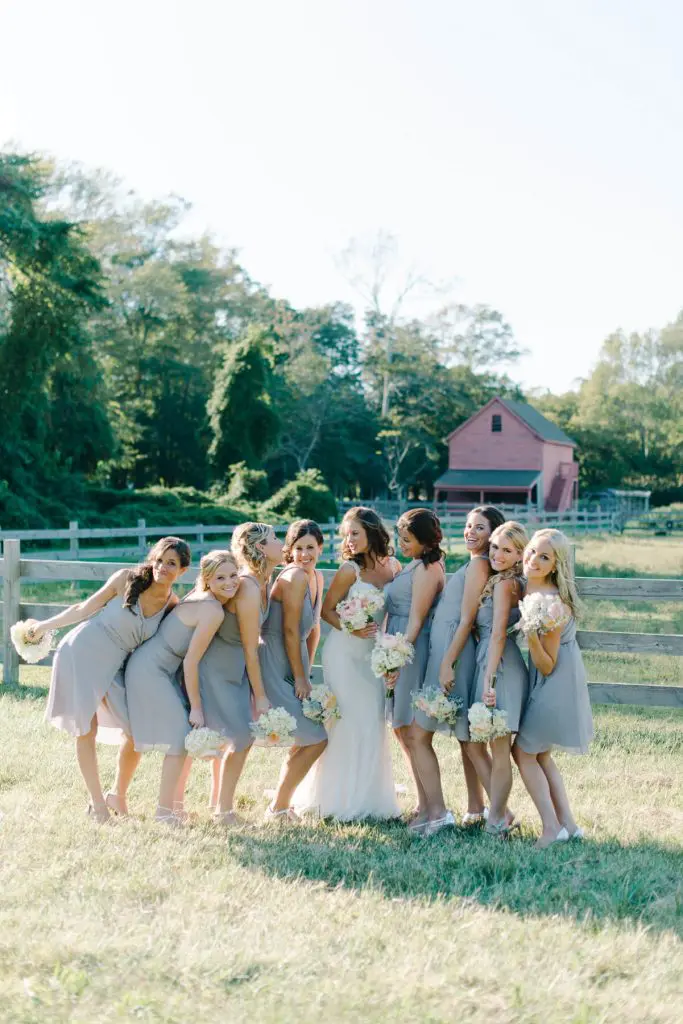 bride and bridesmaids posing in front of old red barn cape may new jersey