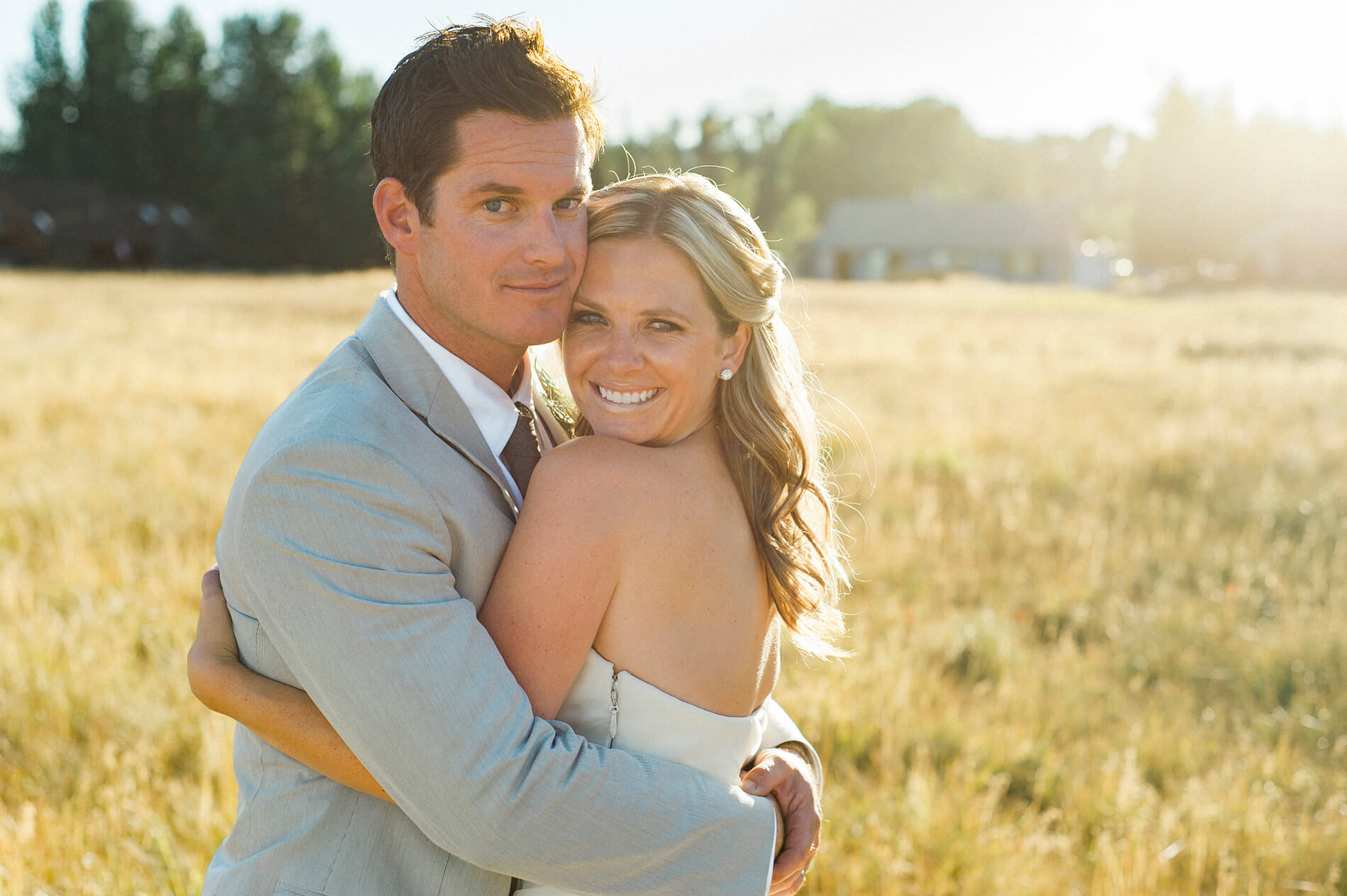 bride and groom embracing in field after lake almanor destination wedding