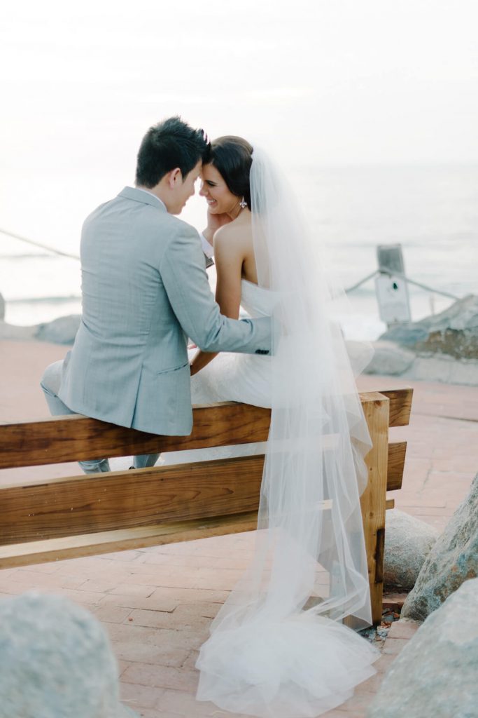bride and groom posing on bench san diego beach wedding lauberge del mar