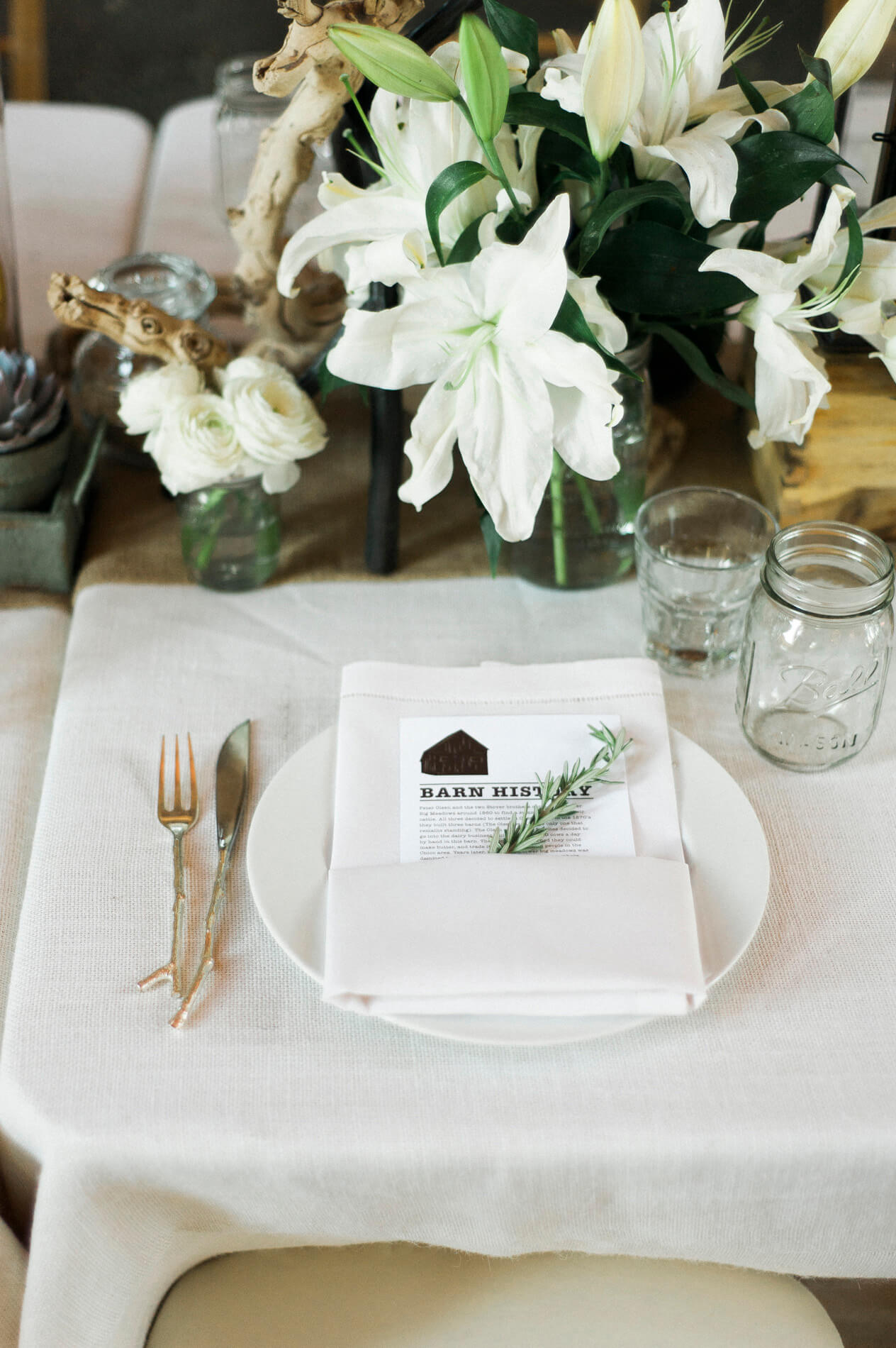 place setting with gold flatware and barn history dinner menu