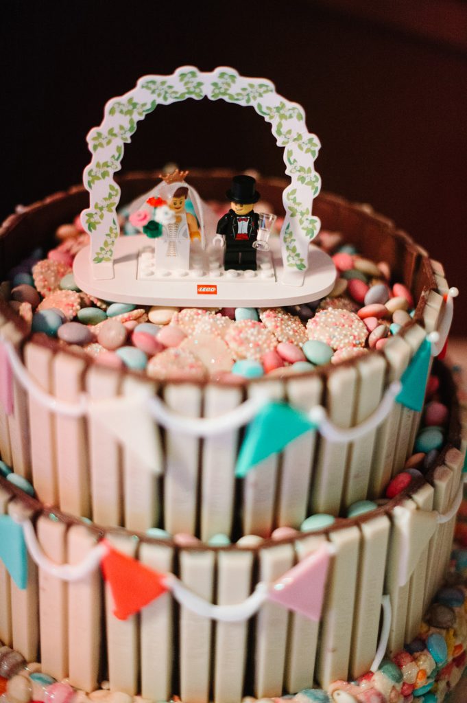 wedding cake covered in candy with lego bride and groom topper 