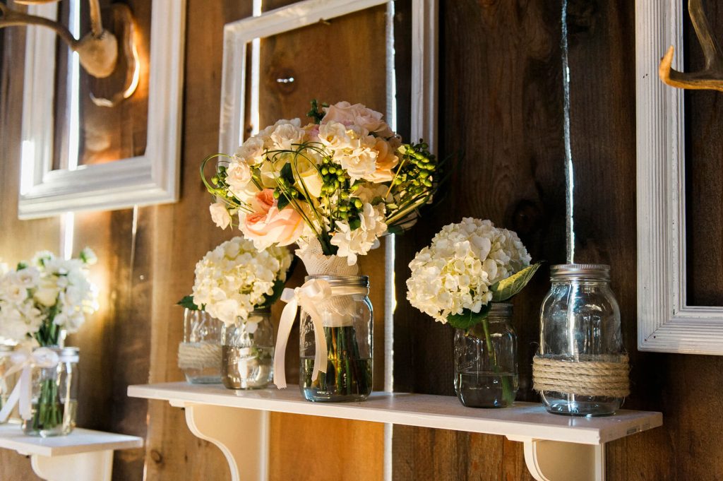 brides bouquet in mason jar resting on shelf rustic barn wedding