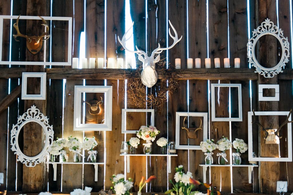 empty white frames and flowers on shelves and white decorative deer head rustic barn wedding lake almanor