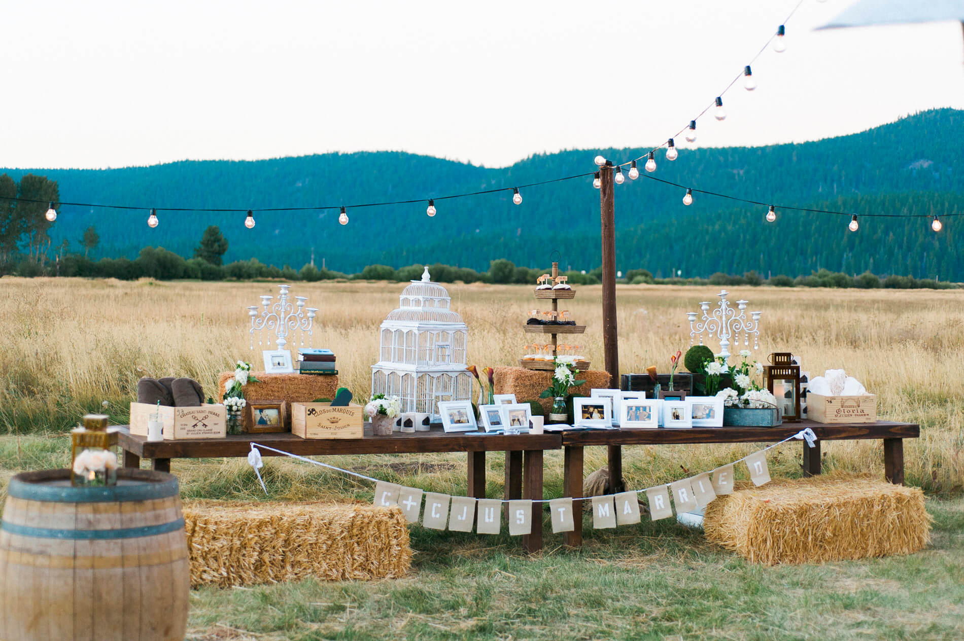 long wooden dessert table in field during rustic barn wedding in lake almanor