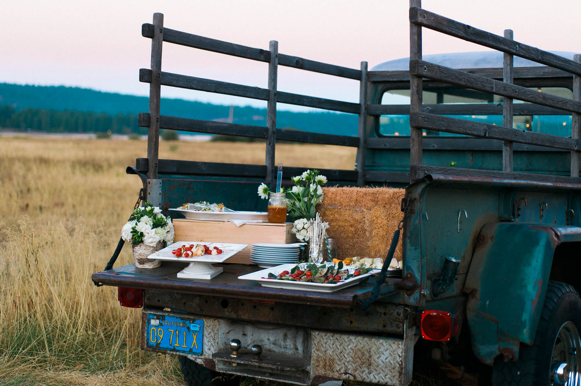 appetizers and flowers and hay in back of vintage pickup truck