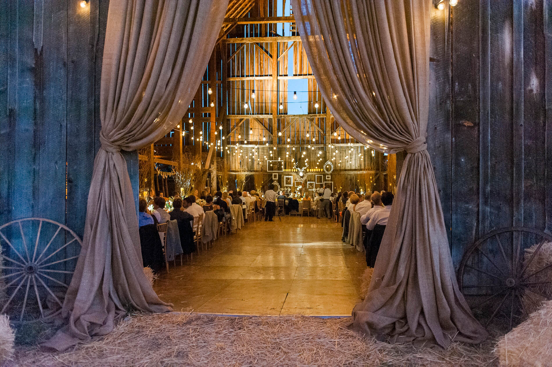 large canvas drapes framing entrance to rustic barn wedding reception