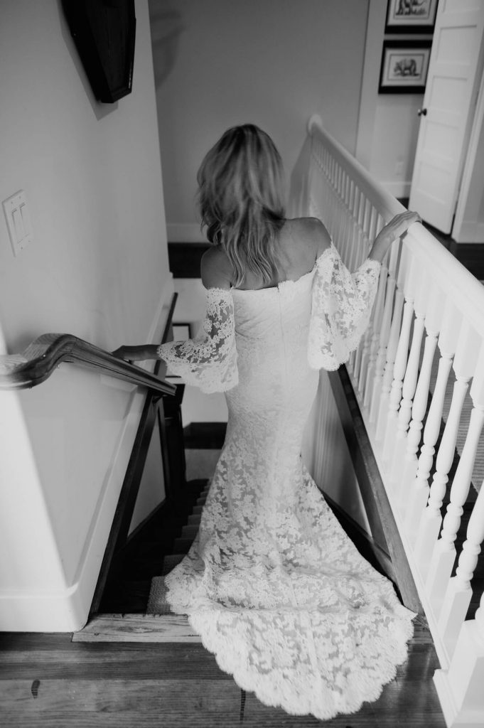 bride in reem acra gown walking down stairs