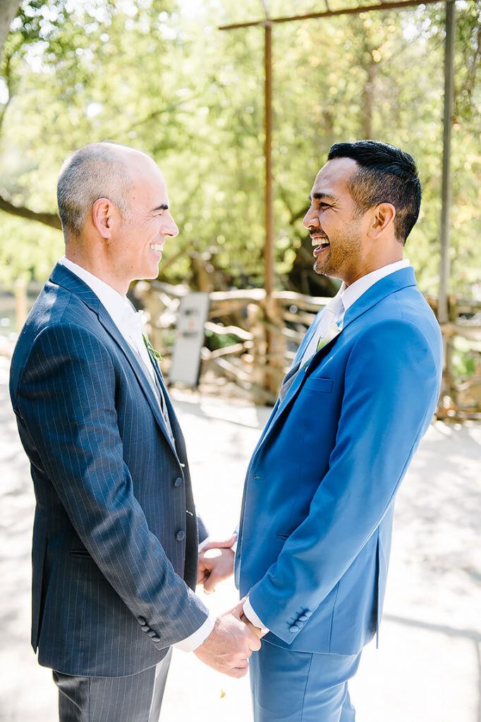 two grooms holding hands calamigos ranch same sex wedding