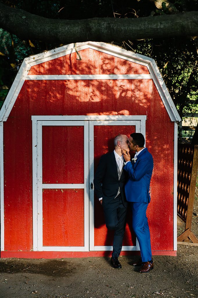 two groom kissing red barn same sex wedding calamigos ranch