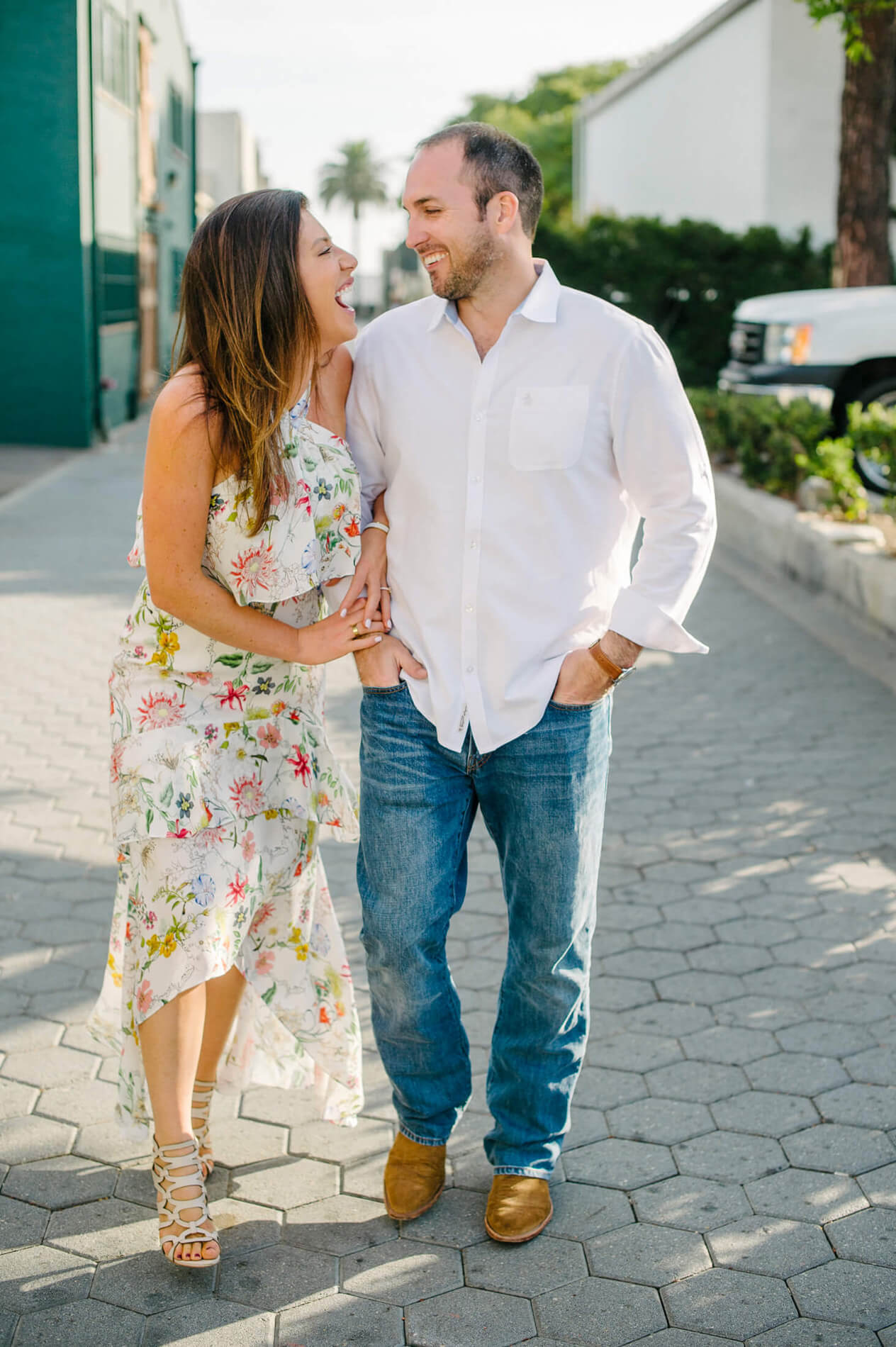 couple laughing and walking in alley laguna beach engagement