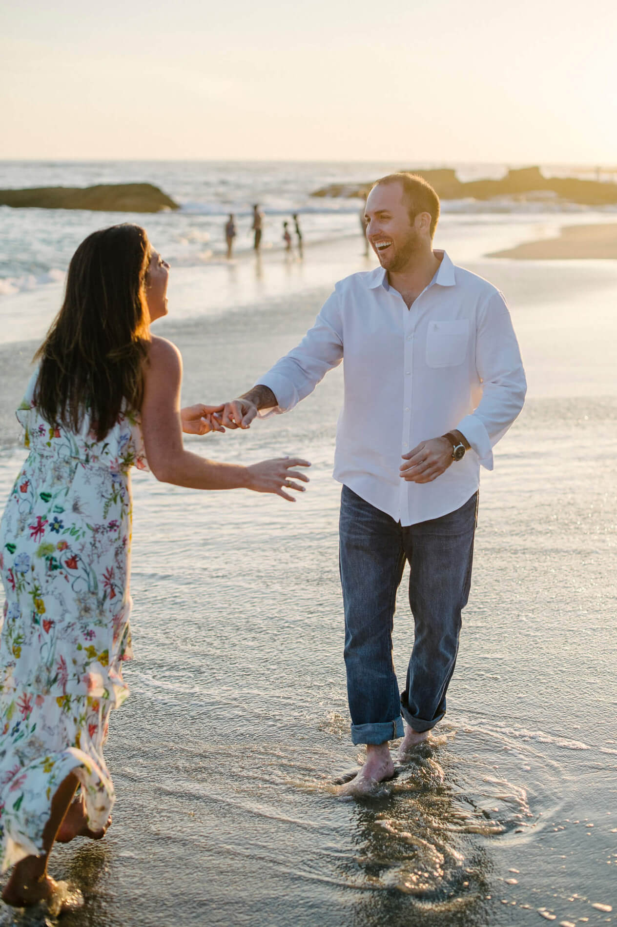 couple laughing on beach montage laguna engagement