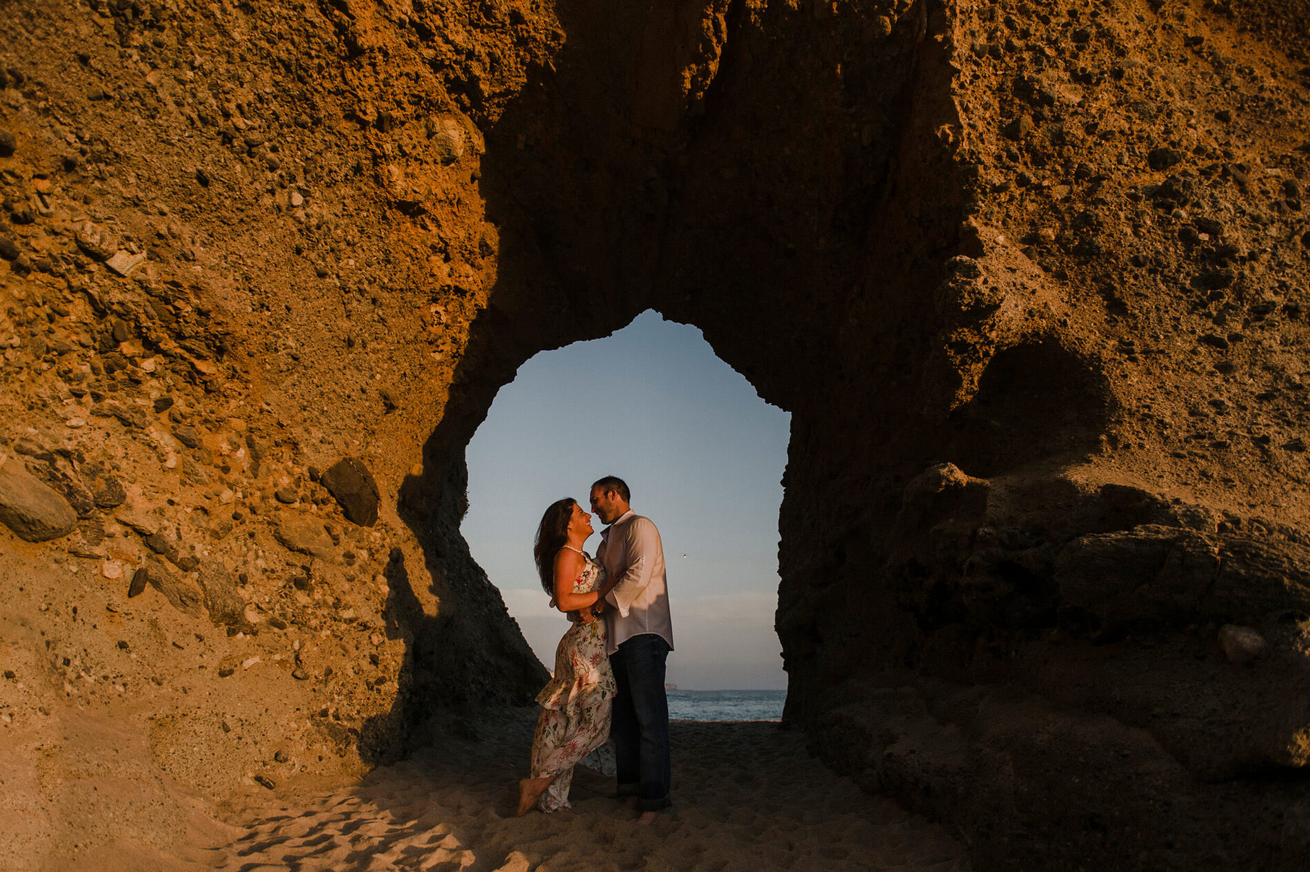 couple posing at sunset in cave laguna beach engagement