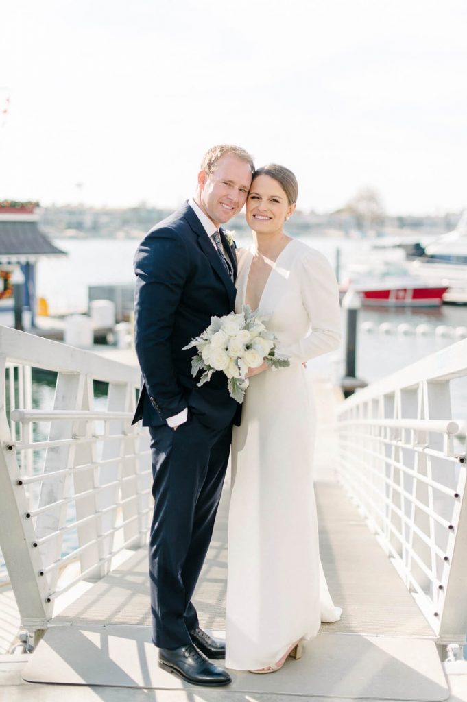 bride and groom posing on dock balboa bay club